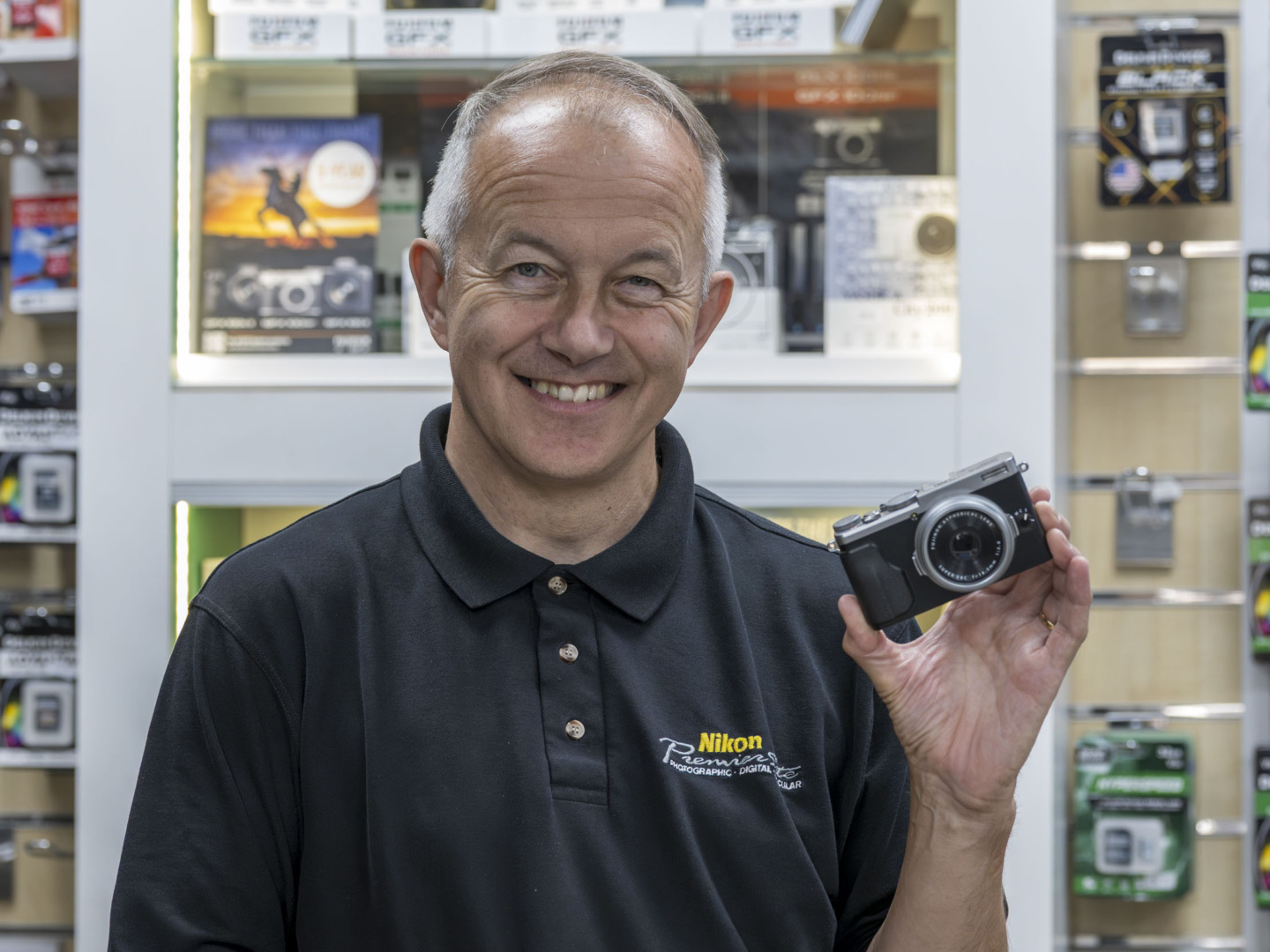 man in camera shop holding camera