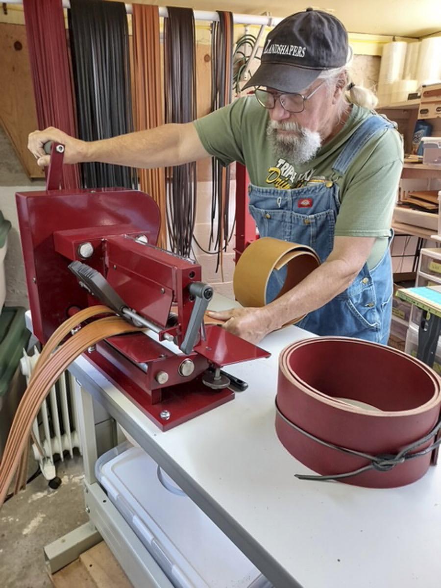 Man working on leather cutting machine