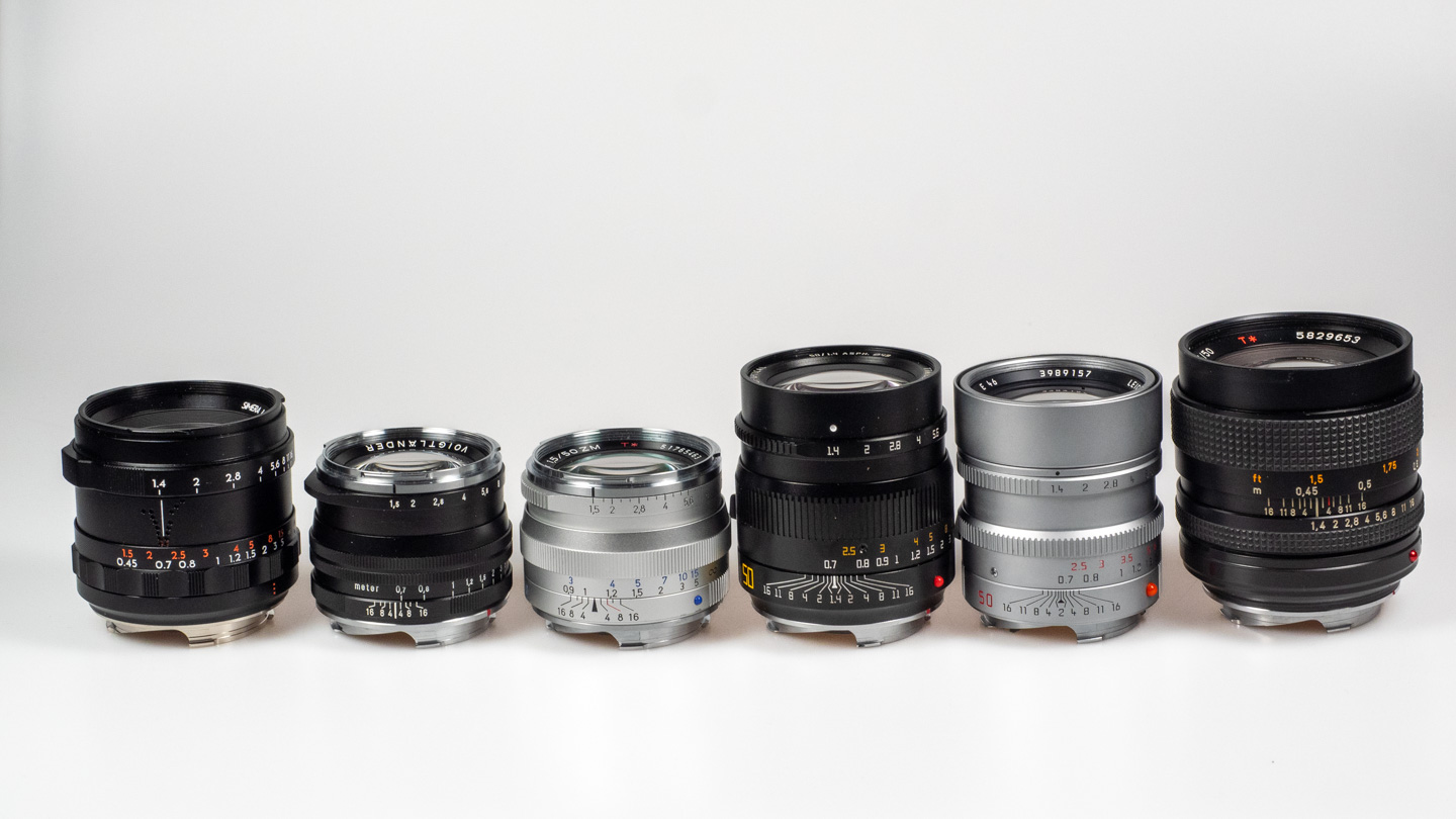 Product shot of Thypoch Simera 50/1.4: lined up with other fast 50mm M-mount lenses on a white background.