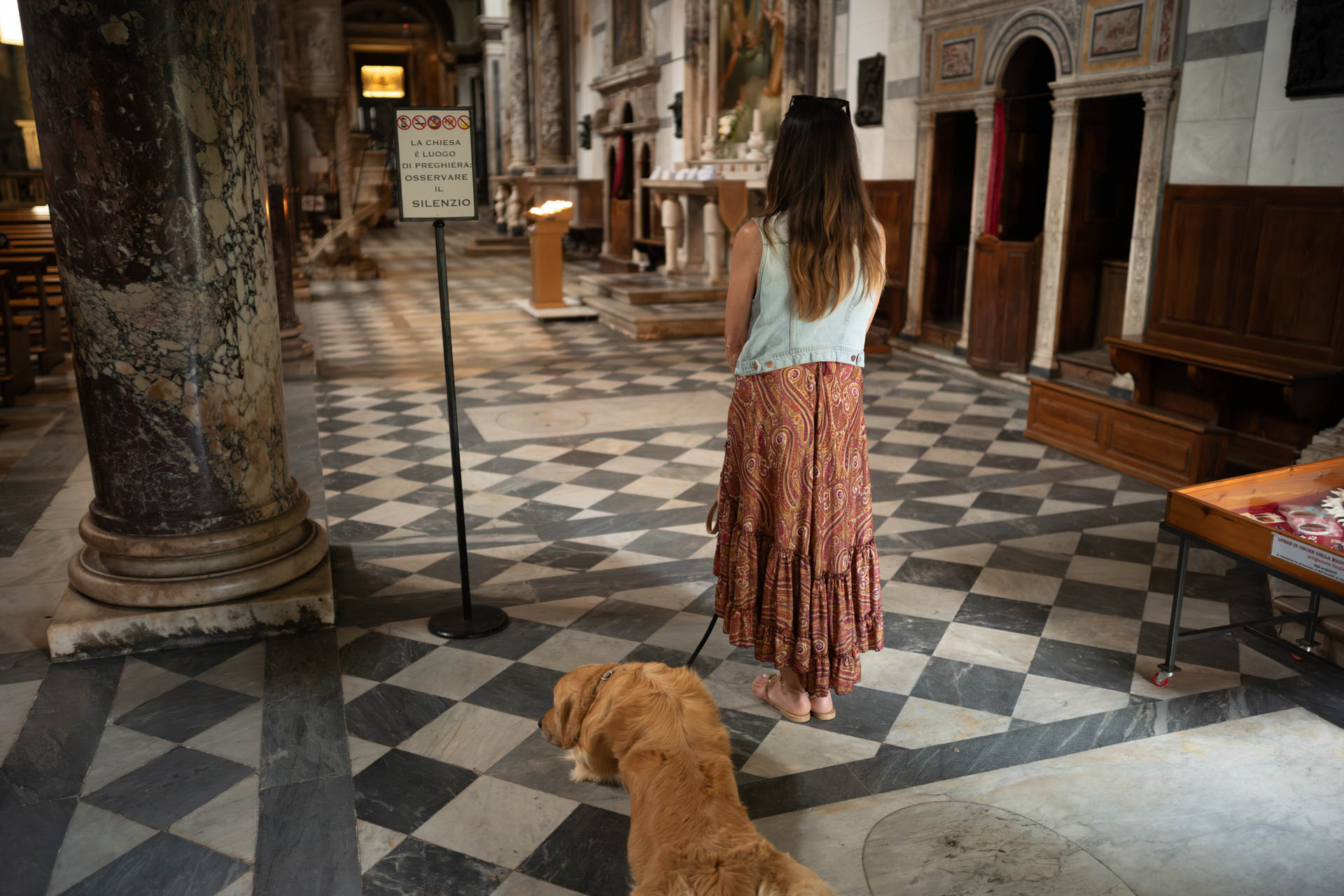 Sample shot with Thypoch Simera 50/1.4: a woman and her golden retriever standing on the chequered marble floor of a church in Camaiore (Province of Lucca), Italy.