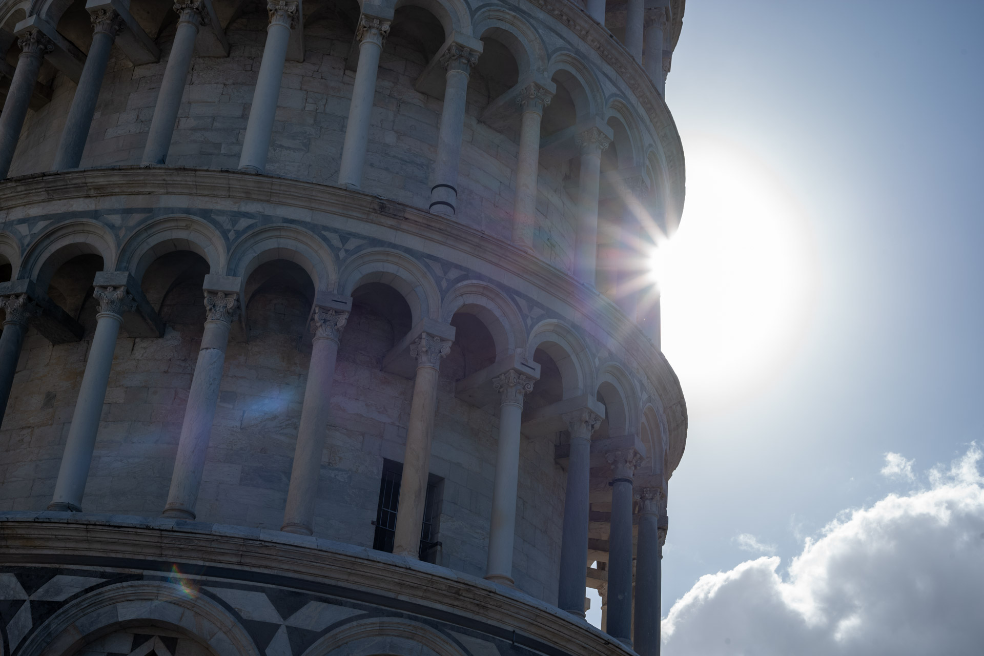 Sample shot with Thypoch Simera 50/1.4: sunlight bursting between the arcaded tiers of the Leaning Tower of Pisa, Italy.