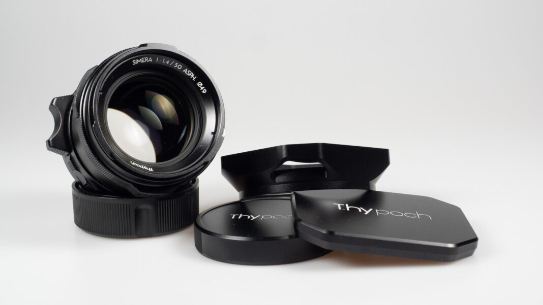 Product shot of Thypoch Simera 50/1.4: the lens beside its hood, front cap and rear cap.