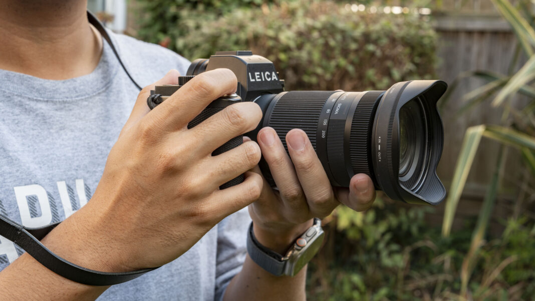 Man holding Leica SL3 with Sigma 20-200 lens feature