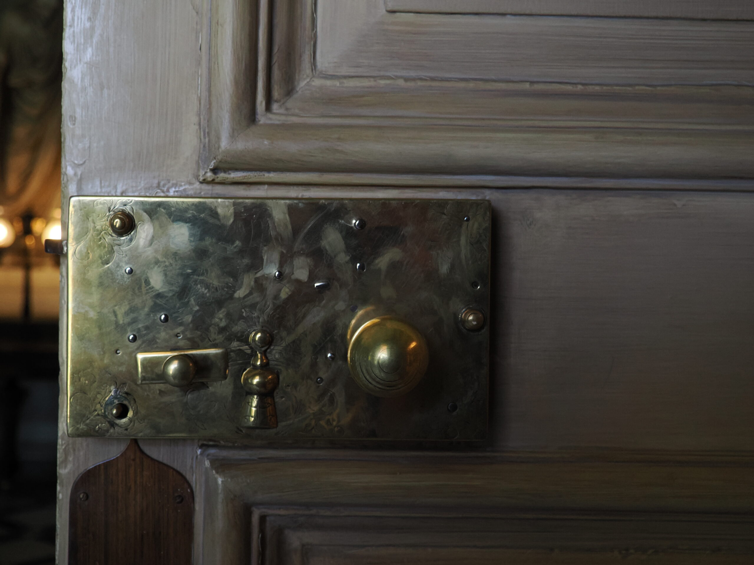 Close-up of a vintage door lock with brass fittings and a decorative design.