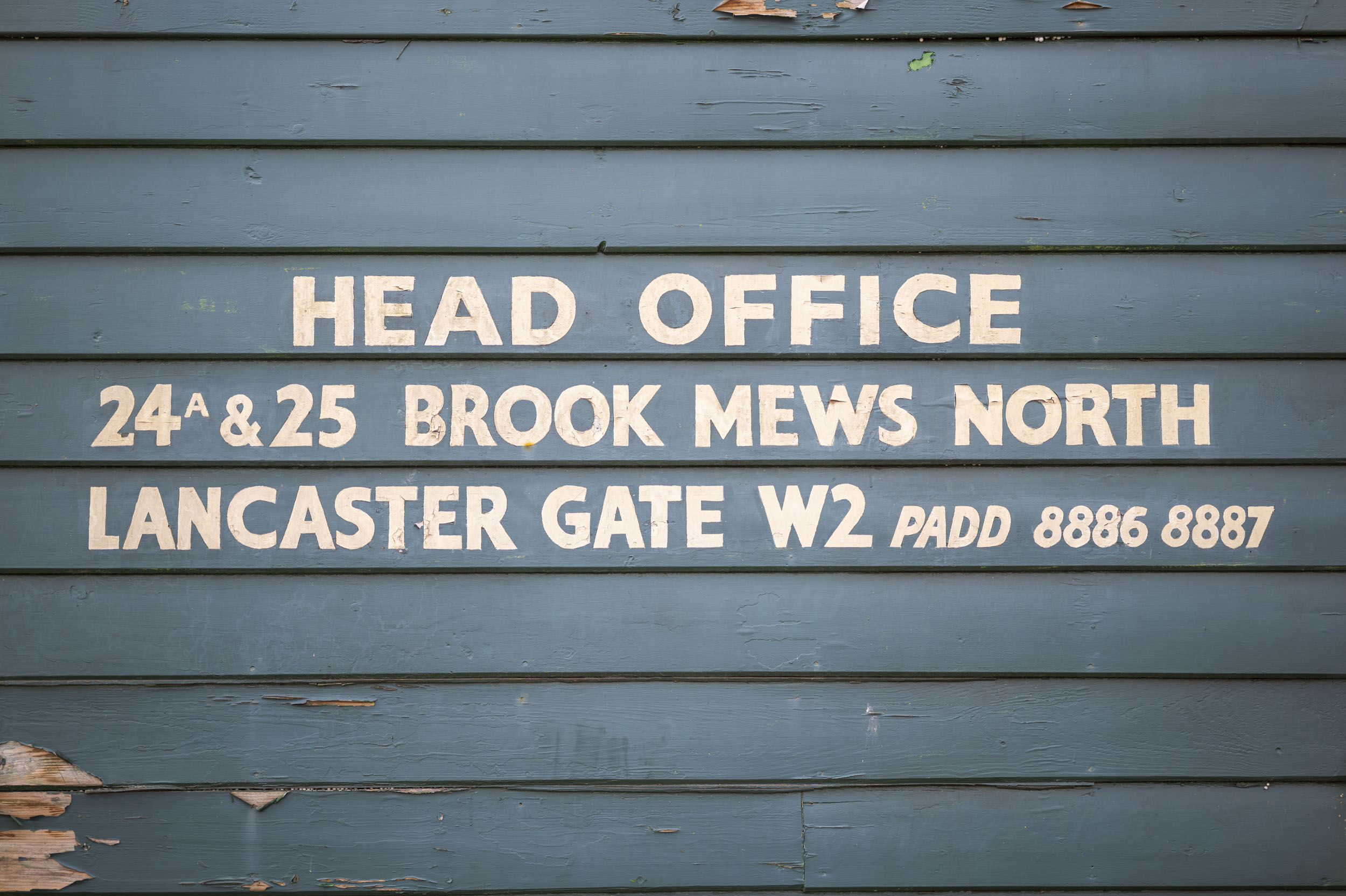 A hand-painted 'Head Office' sign on weathered clapboard, part of an aperture test series.