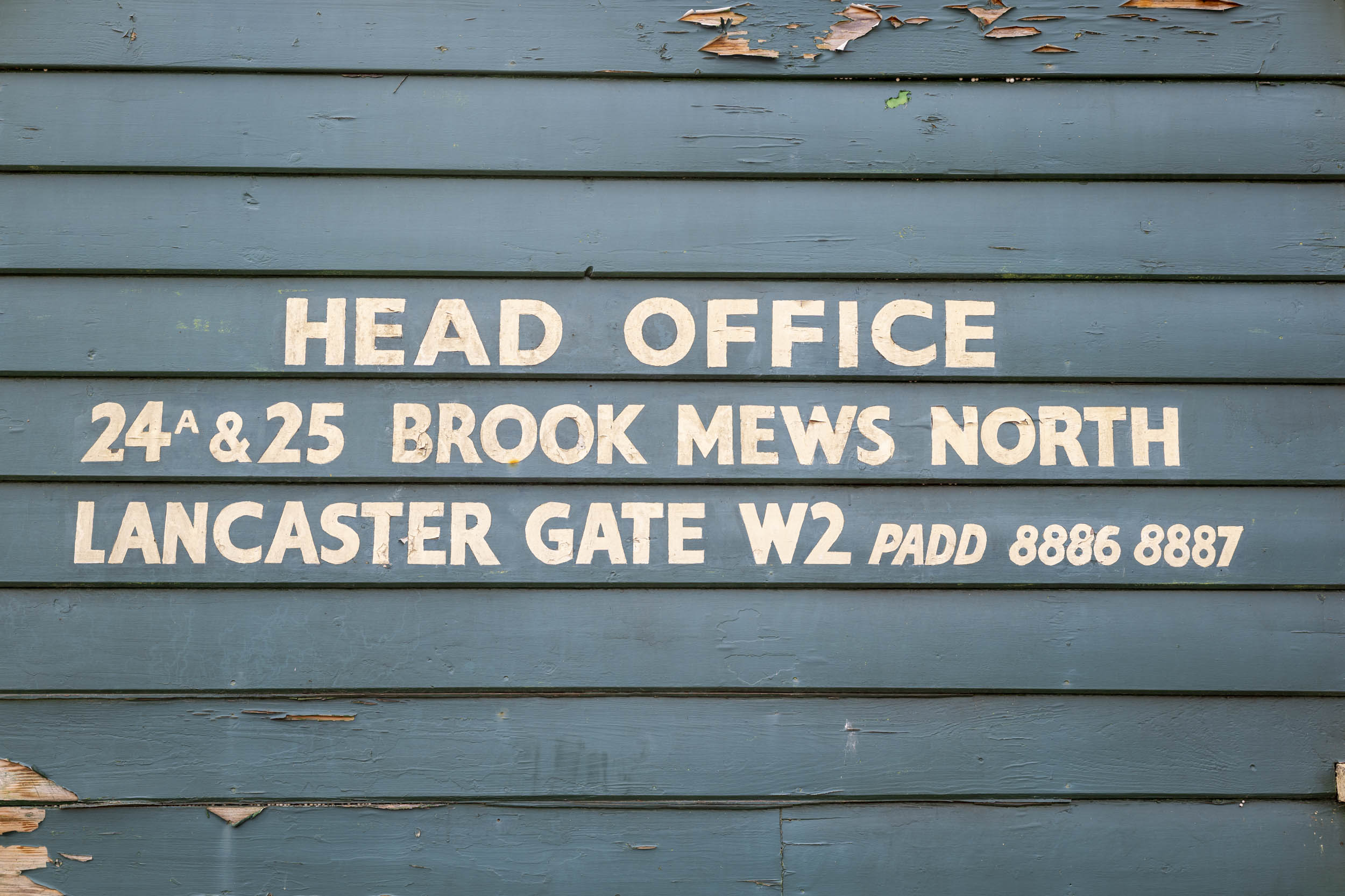 A hand-painted 'Head Office' sign on weathered clapboard, part of an aperture test series.