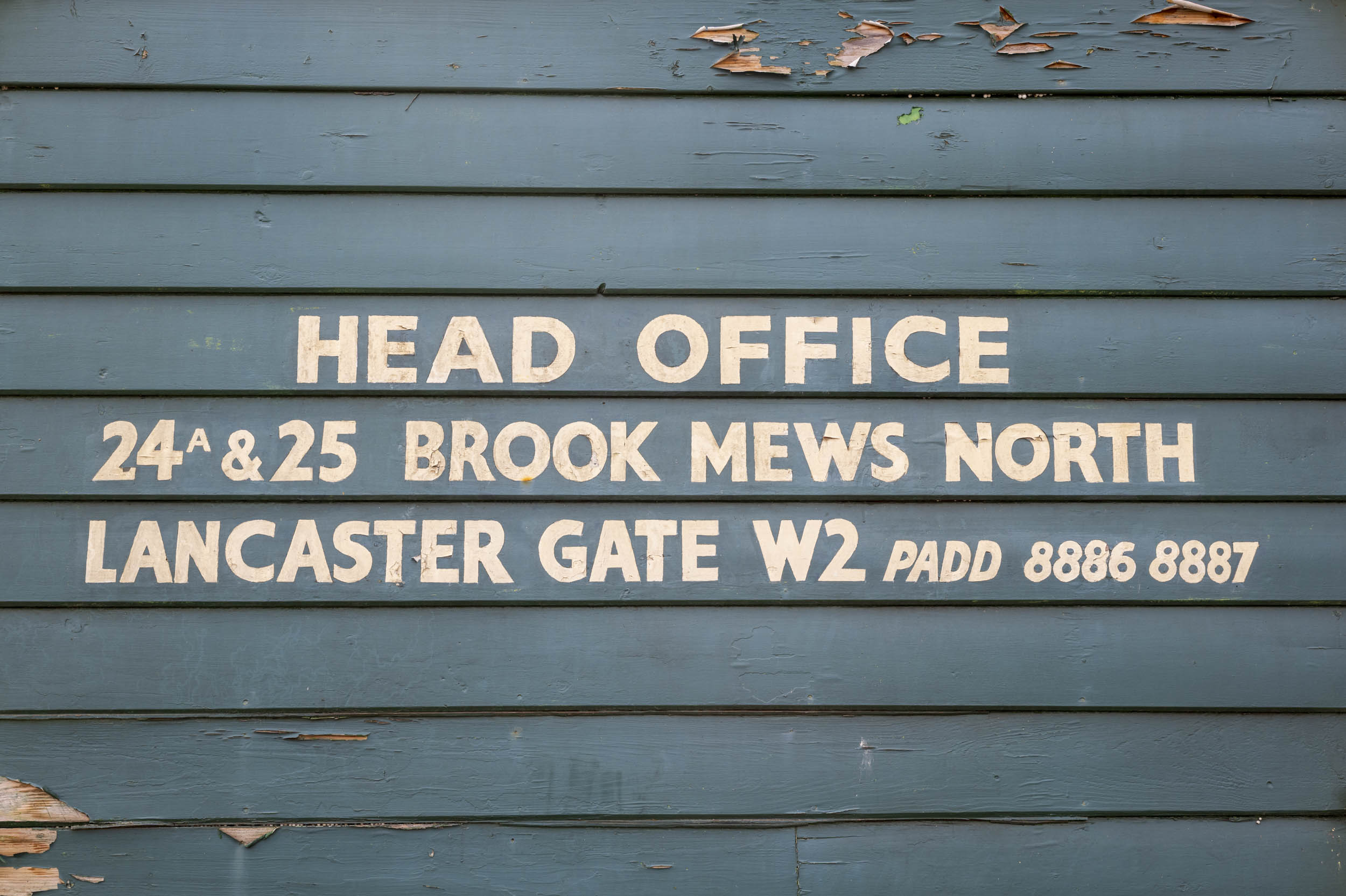 A hand-painted 'Head Office' sign on weathered clapboard, part of an aperture test series.