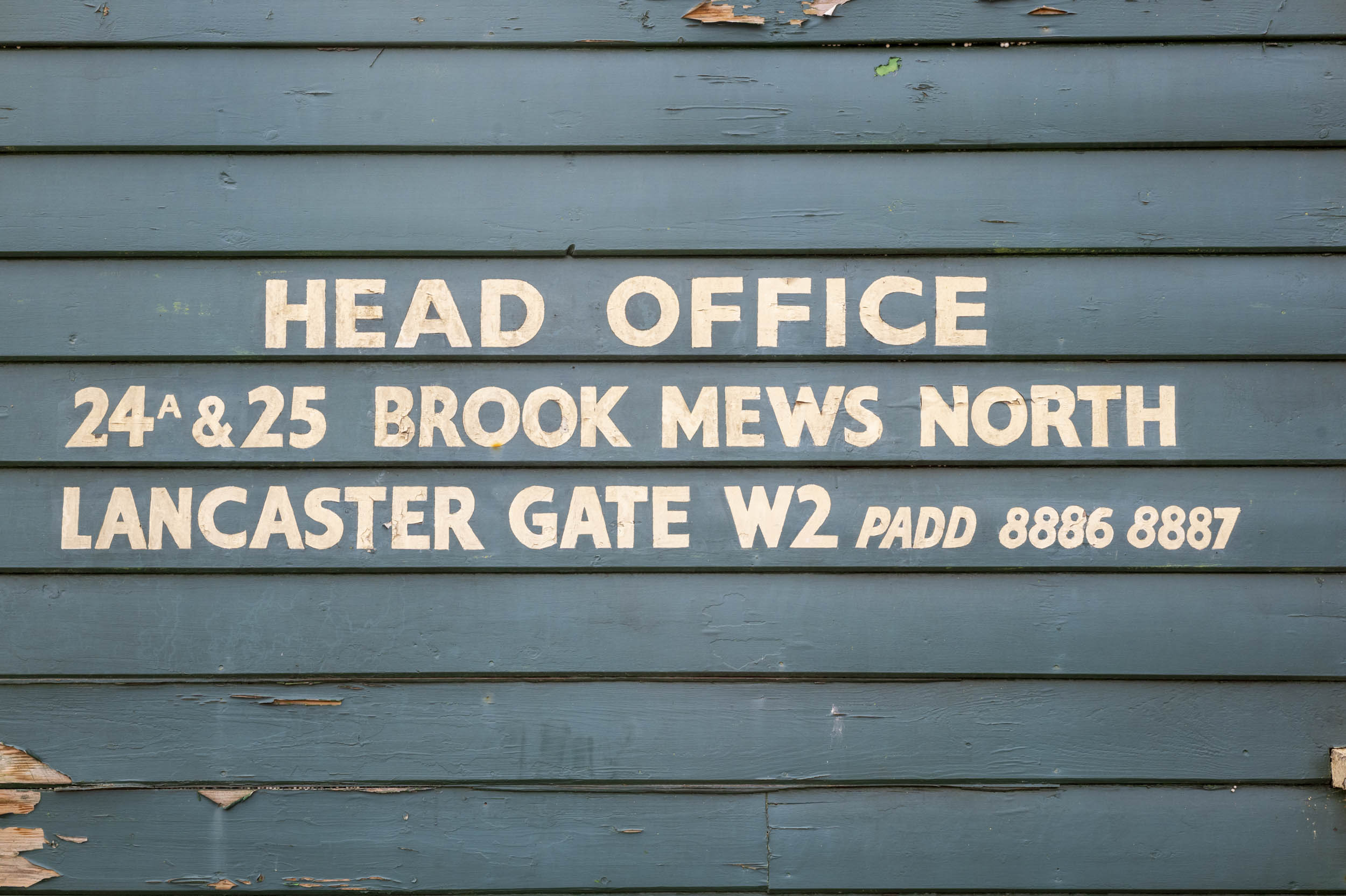 A hand-painted 'Head Office' sign on weathered clapboard, part of an aperture test series