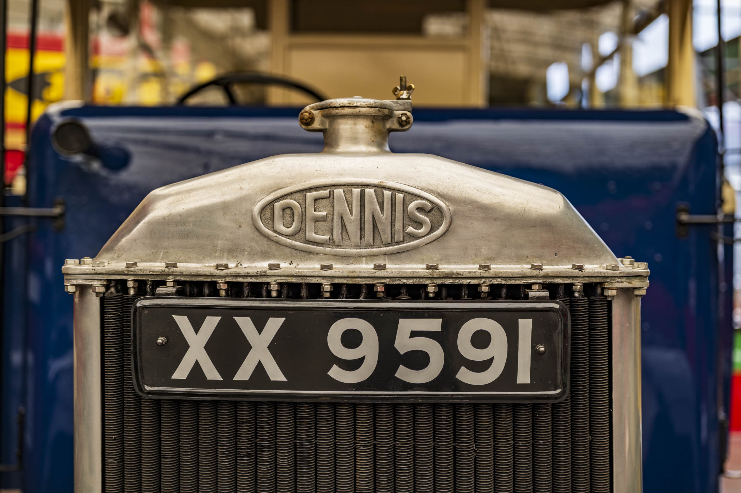 The embossed radiator badge and registration plate of a vintage Dennis vehicle