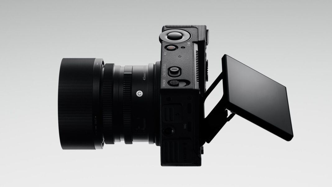 Overhead view of the Sigma FP2 with a 45mm lens fitted and its rear screen tilted outwards, showing the mode switch, record button and side ports.
