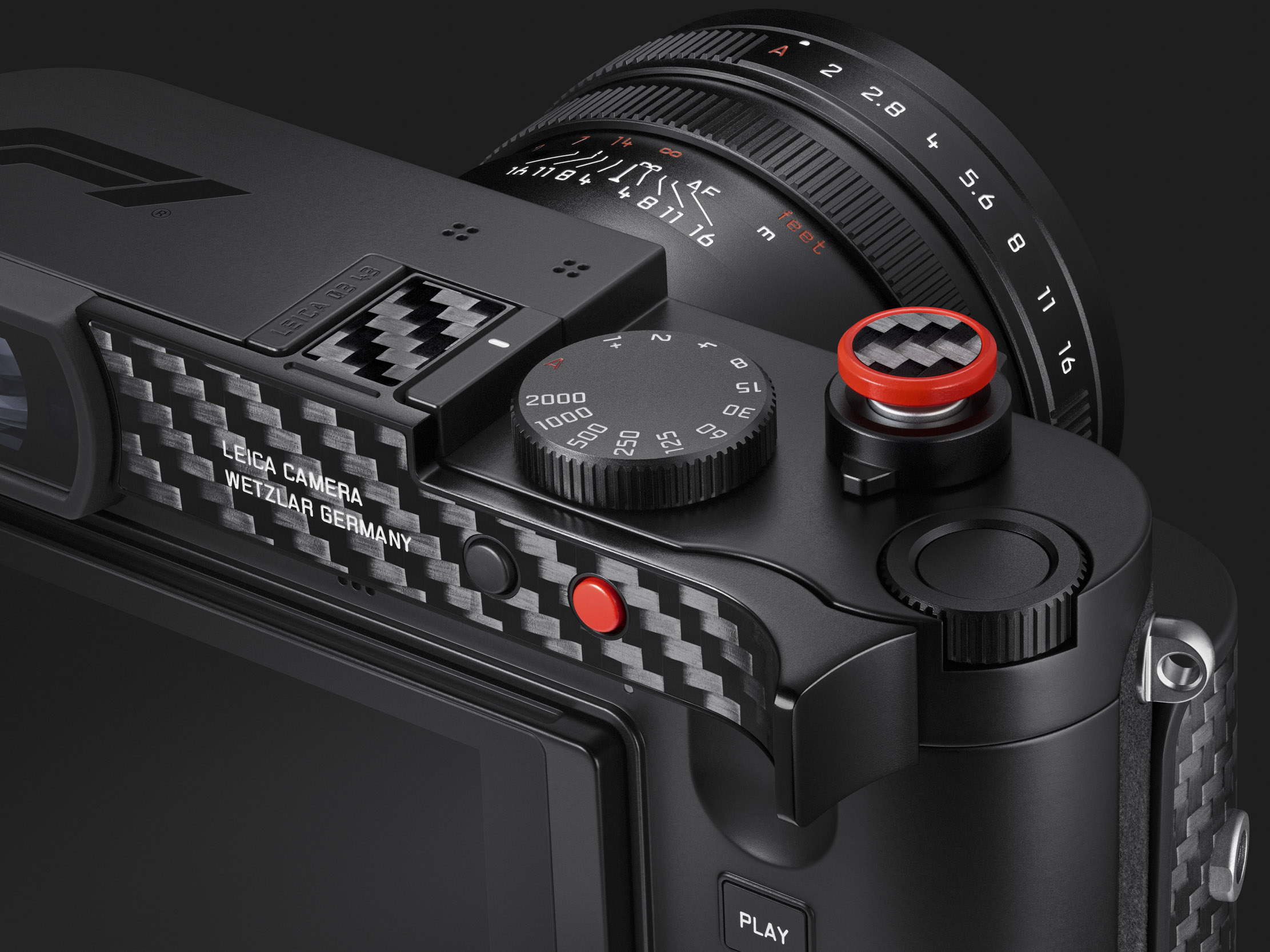 Close-up of the top and rear of the camera: the carbon fibre thumb rest with its red function button, the shutter-speed dial and the red-rimmed carbon soft-release button.