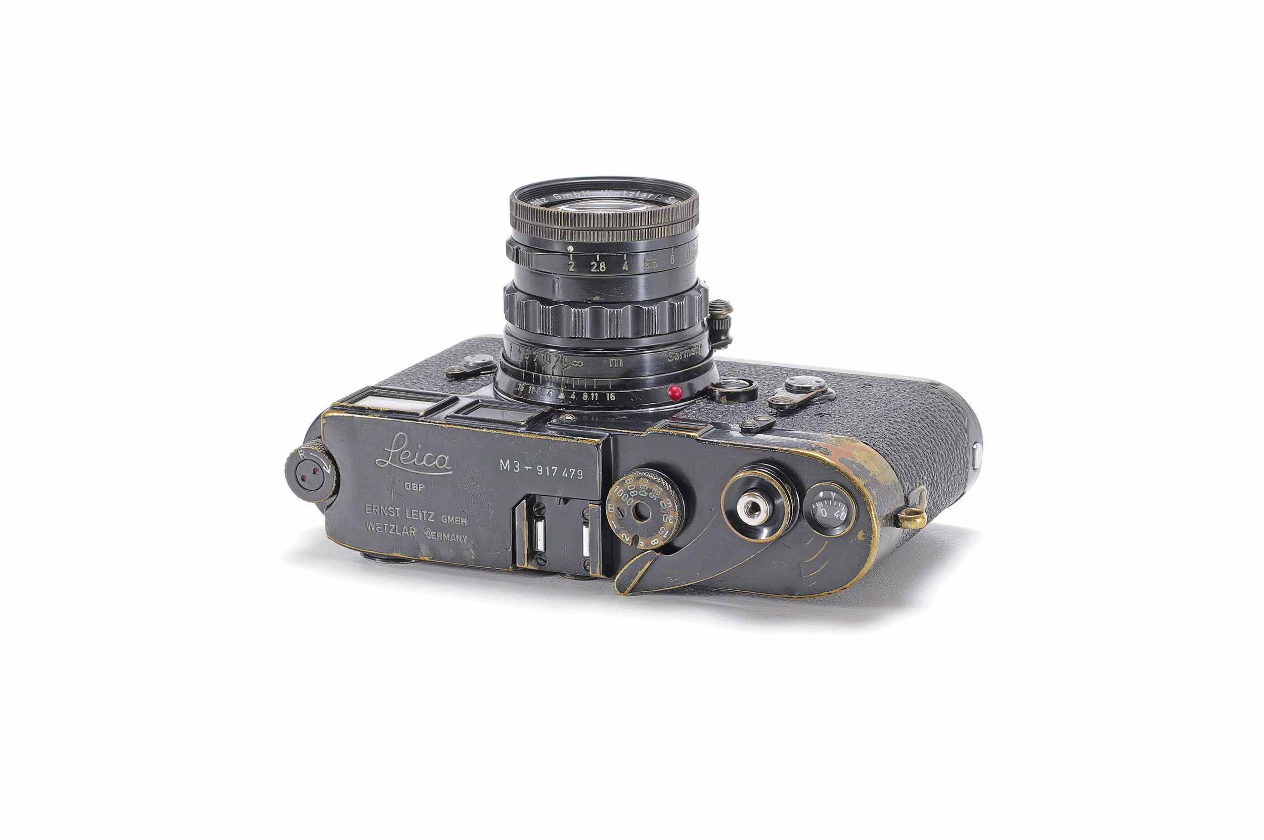 Top view of a black-paint Leica M3 with brass showing through worn paint, fitted with a black Summicron lens.